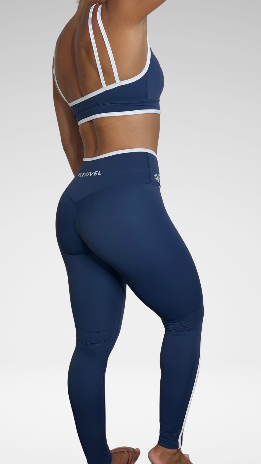 Donna indossa leggings sportivi Flexivel blu, vista laterale con top coordinato