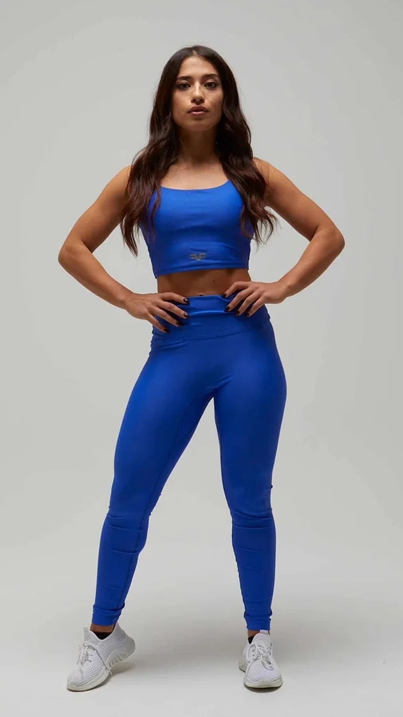 Modella con completo sportivo blu elettrico Flexivel, leggings a vita alta e top, frontale