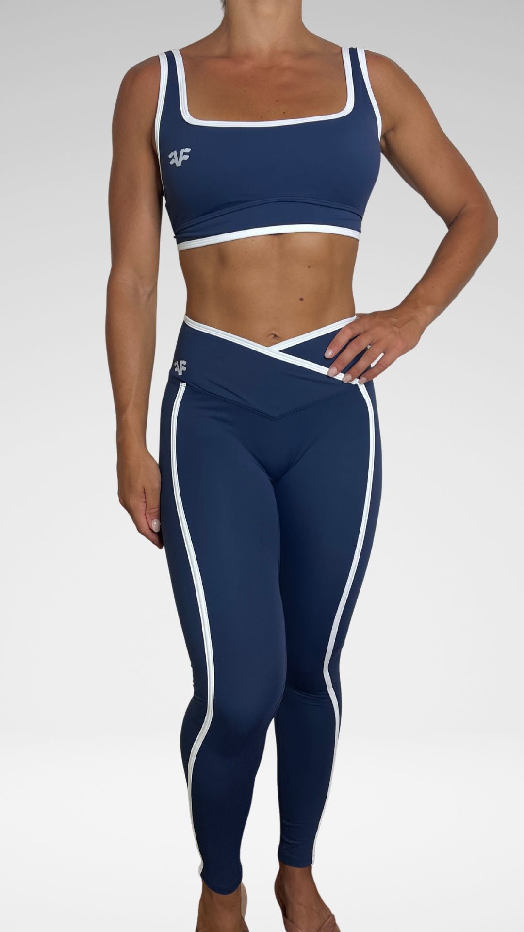 Donna indossa leggings sportivi Flexivel blu a vita incrociata con top coordinato, vista frontale
