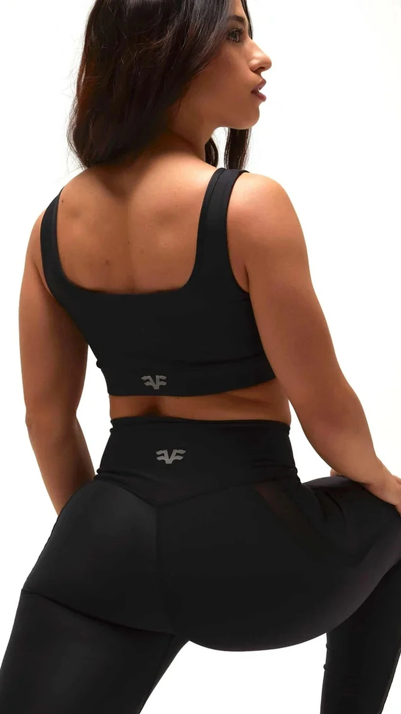 Primo piano posteriore del top sportivo e dei leggings neri Flexivel con logo