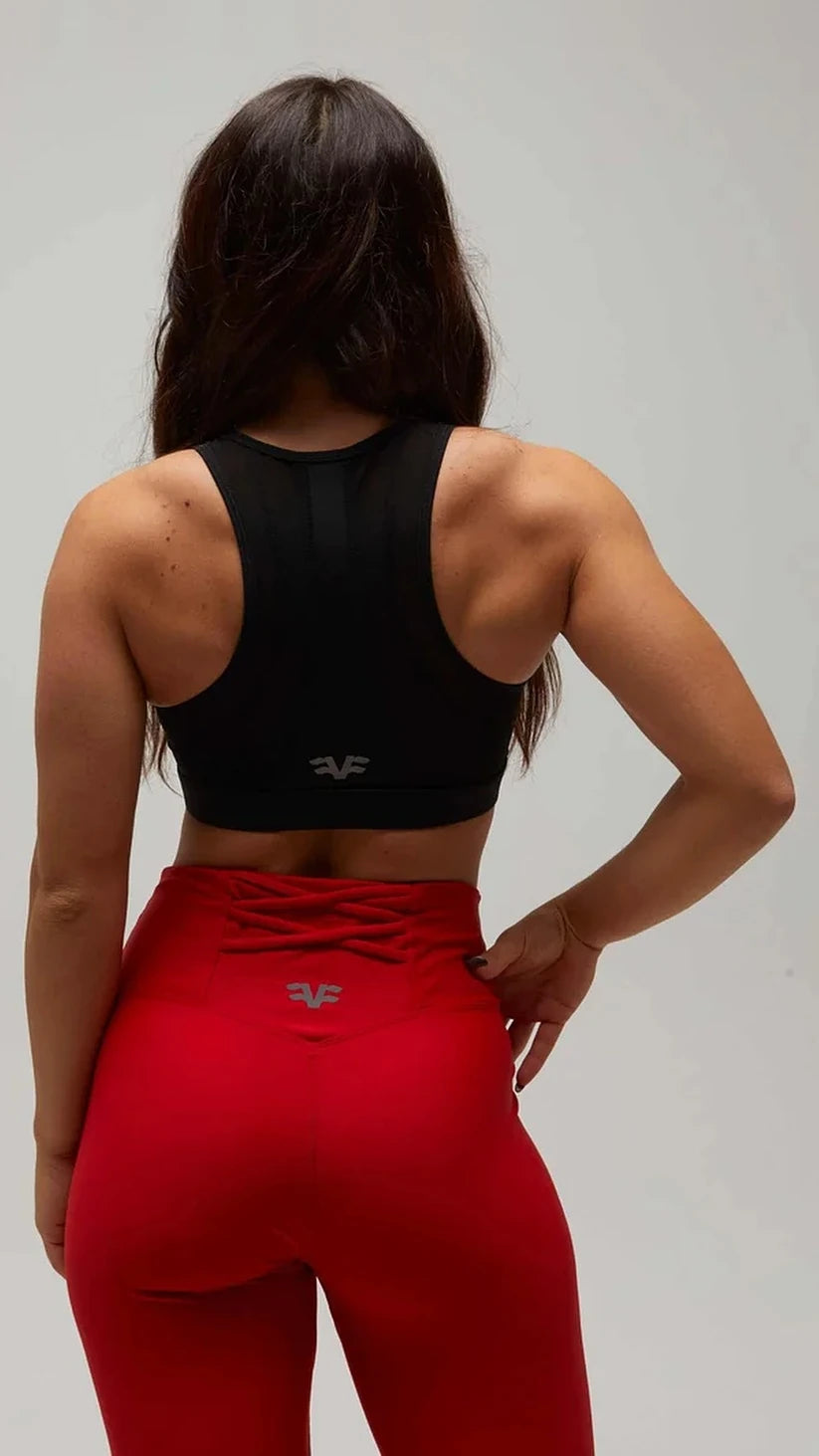 Dettaglio posteriore dei leggings rossi Flexivel con fascia incrociata in vita e top nero
