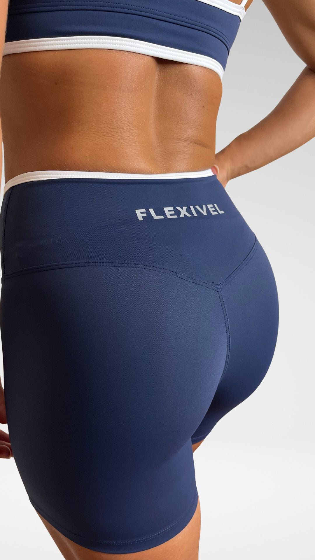 Dettaglio fascia vita incrociata bianca a contrasto dei pantaloncini sportivi Flexivel blu
