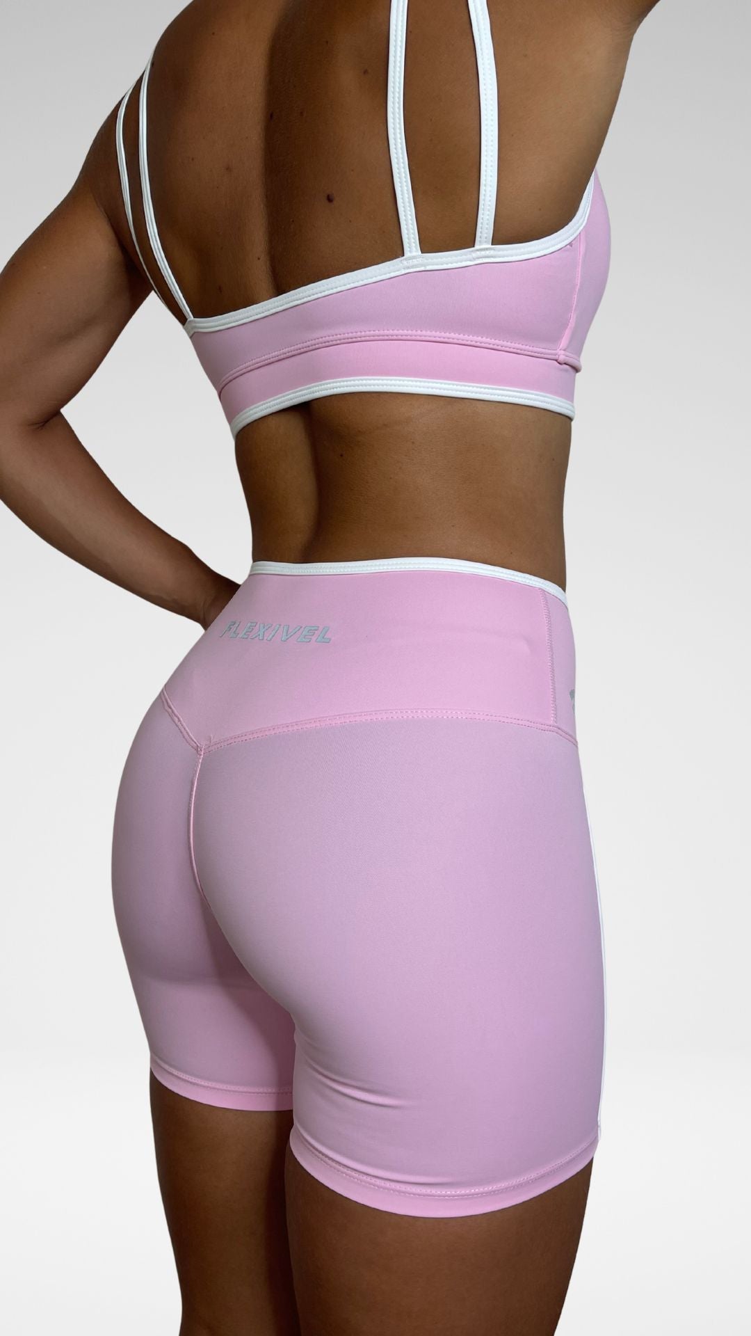 Dettaglio schiena reggiseno sportivo Flexivel rosa con spalline doppie e pantaloncini a vita alta