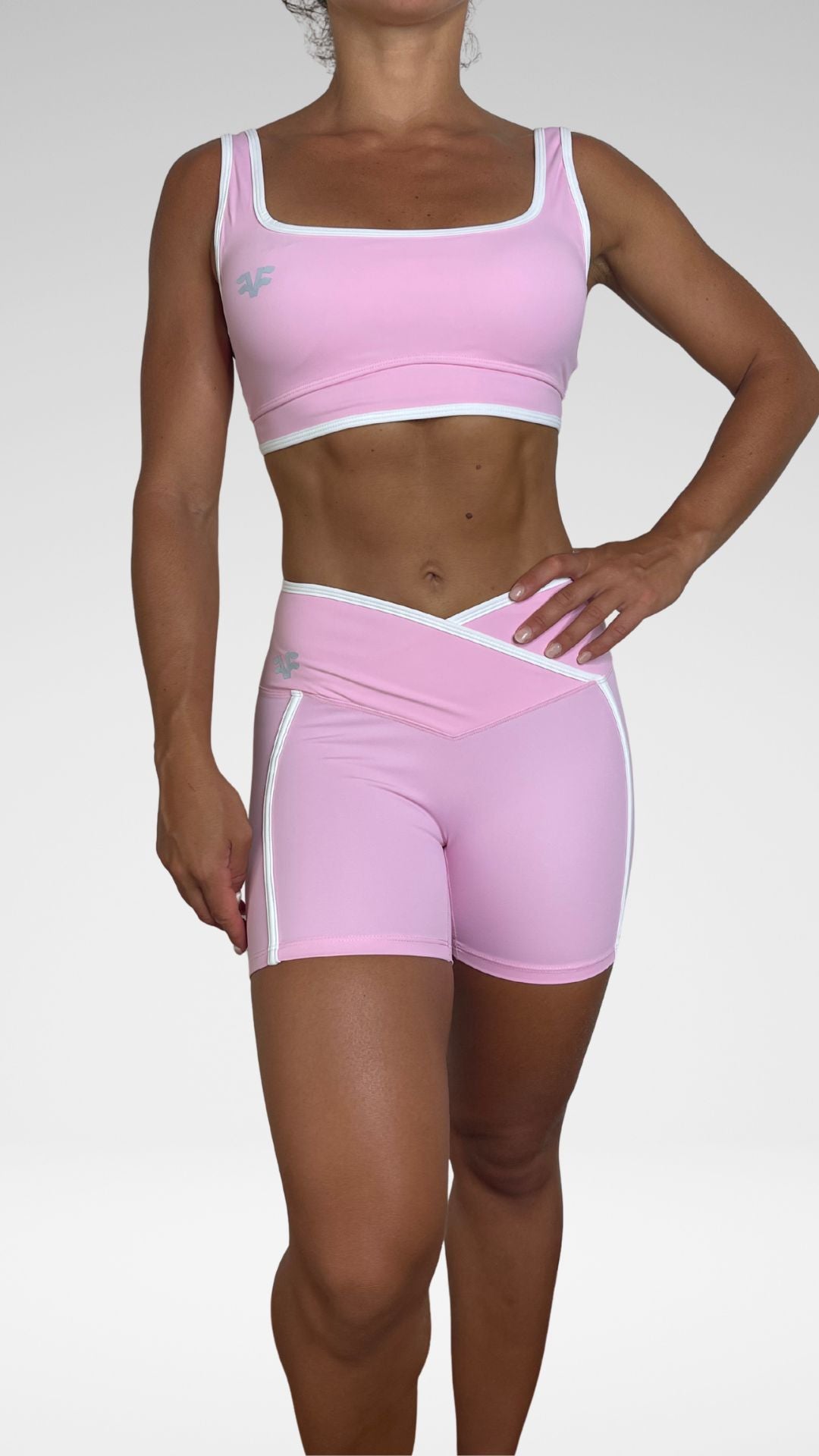 Donna indossa completo Flexivel rosa con leggings a vita incrociata e top coordinato, vista frontale