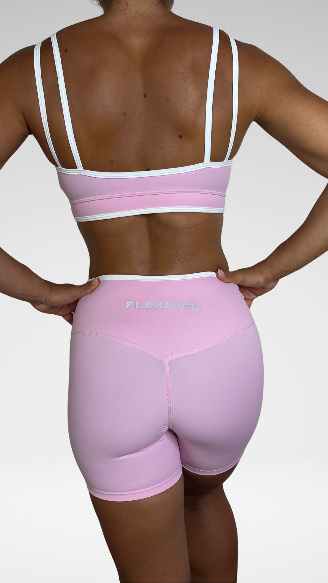 Completo Flexivel rosa reggiseno e pantaloncini sportivi vista posteriore con logo Flexivel