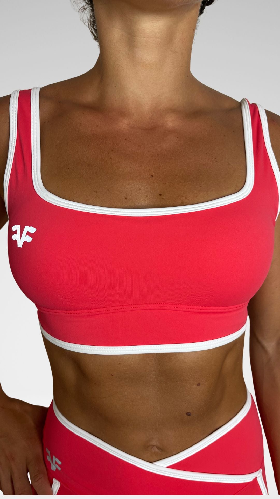 Dettaglio spallina e scollo top sportivo Flexivel coral con profili bianchi a contrasto