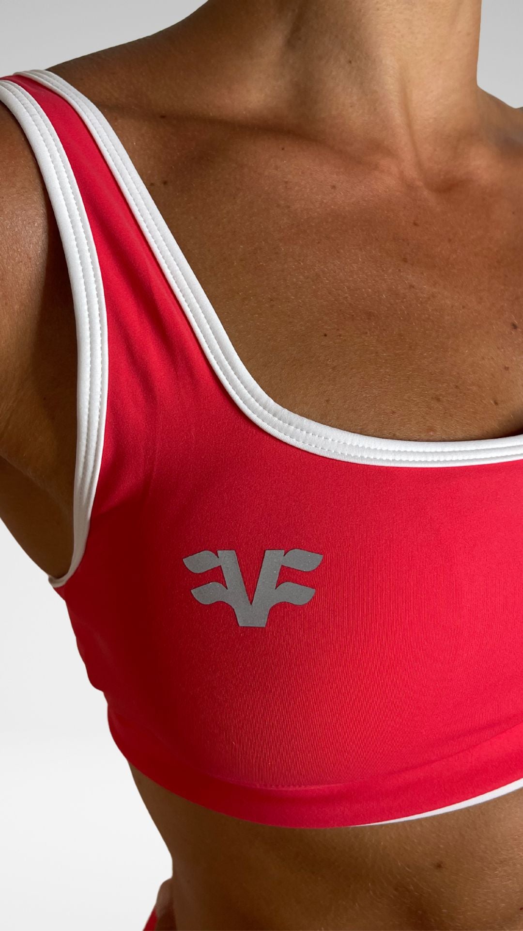 Dettaglio frontale top sportivo Flexivel coral con logo VF e scollo squadrato