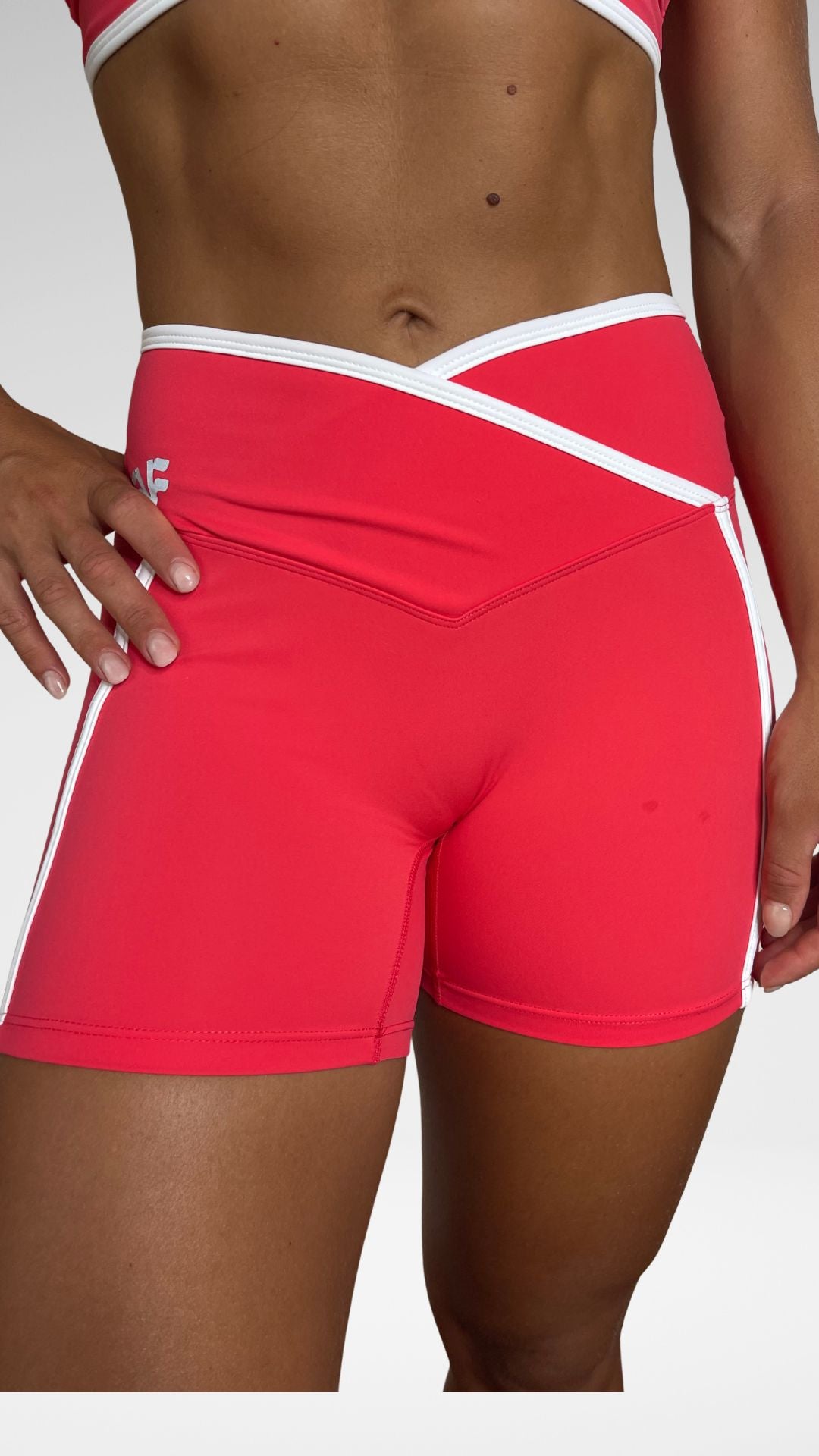 Dettaglio fascia vita incrociata bianca a contrasto dei pantaloncini sportivi Flexivel coral